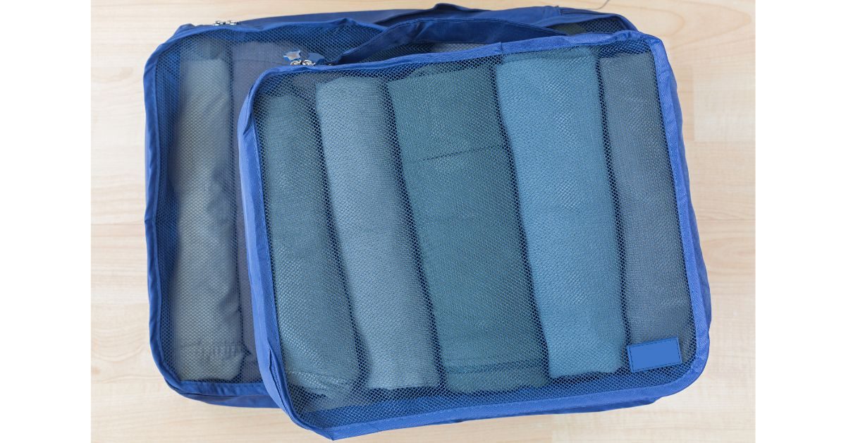 Two blue mesh packing cubes filled with neatly rolled clothes