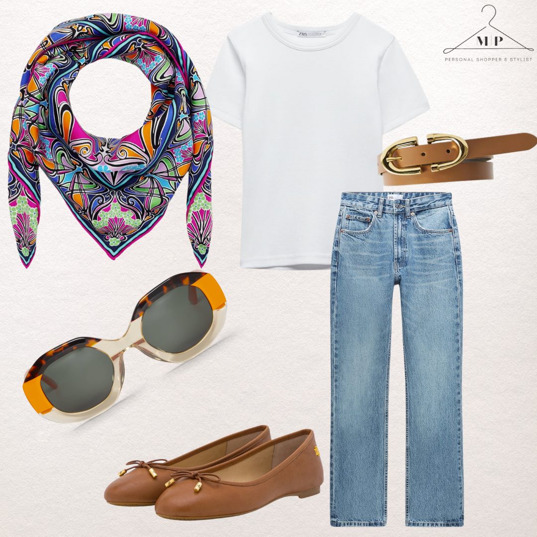 A capsule outfit built on a white T-shirt and straight blue jeans, with a bright paisley silk scarf, tortoiseshell sunglasses, a tan buckle belt and tan ballet flats